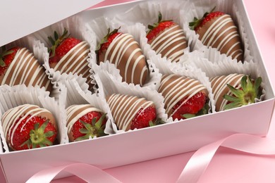 Photo of Box with delicious chocolate covered strawberries on pink background, closeup