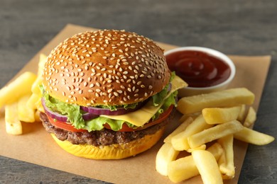 Photo of Burger with delicious patty, french fries and sauce on table, closeup