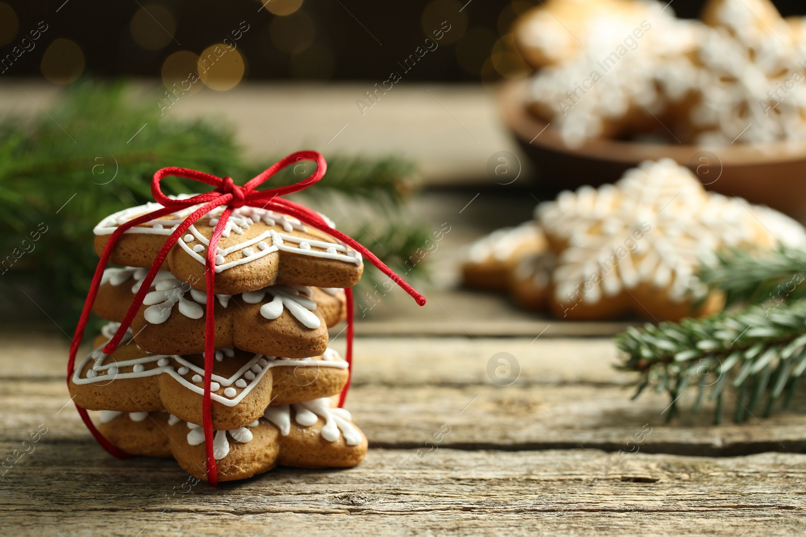 Photo of Tasty Christmas cookies with icing on wooden table. Space for text