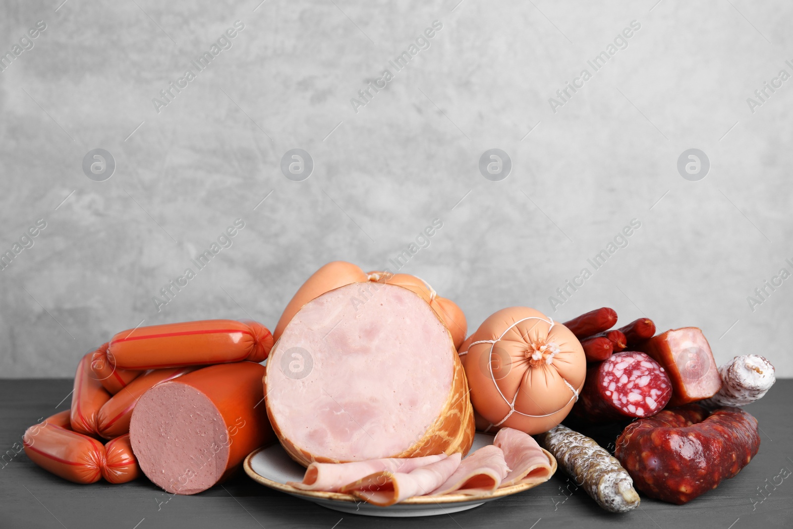 Photo of Different types of sausages on light grey wooden table