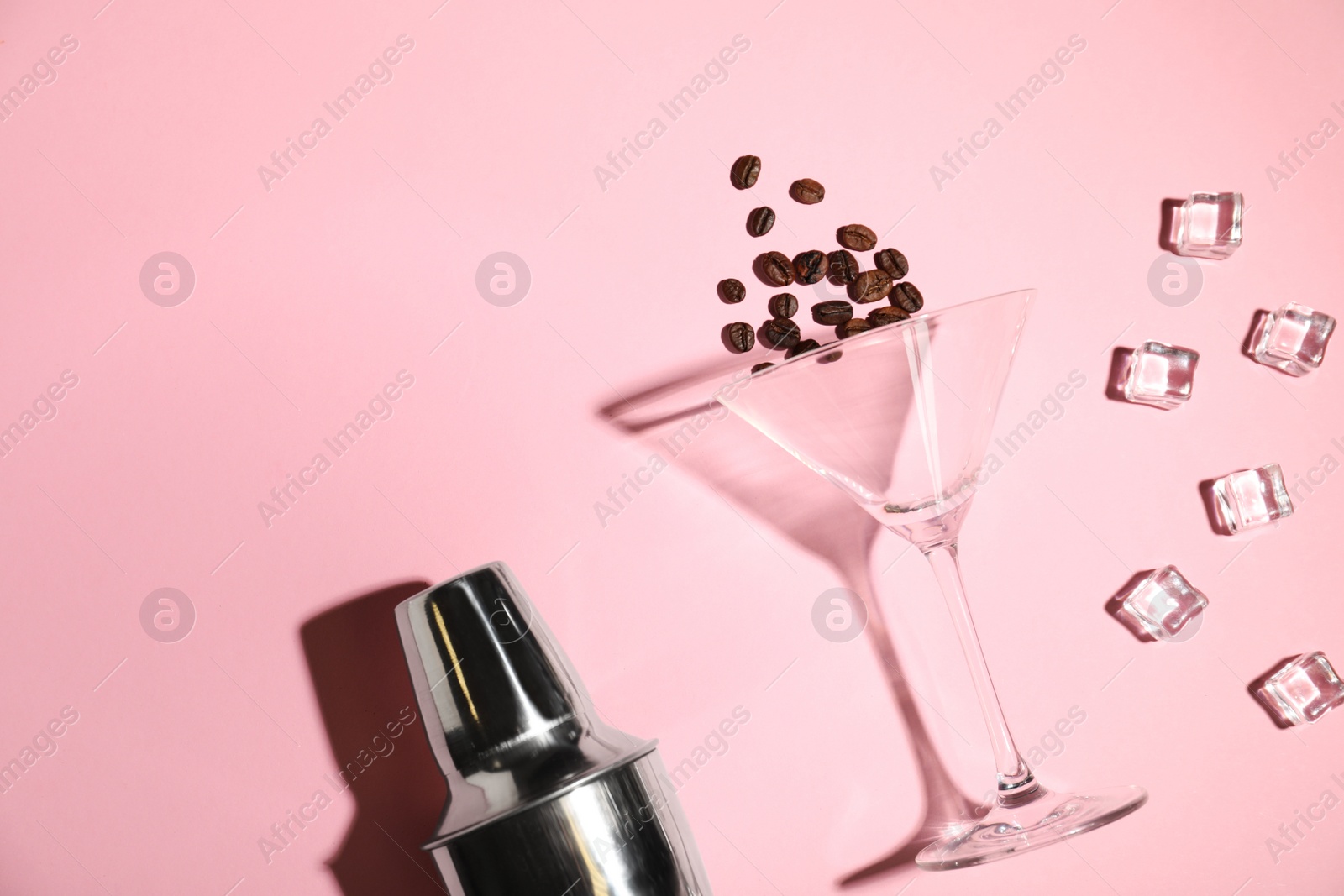 Photo of Flat lay composition with glass, coffee beans, shaker and ice cubes on color background, space for text. Alcohol cocktail recipe - Espresso Martini