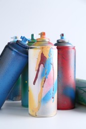 Photo of Many spray paint cans on white background