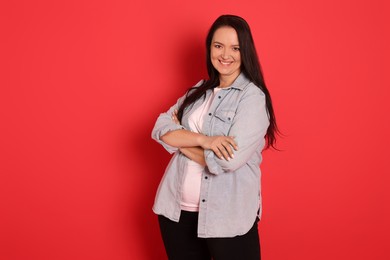 Photo of Beautiful overweight woman with charming smile on red background