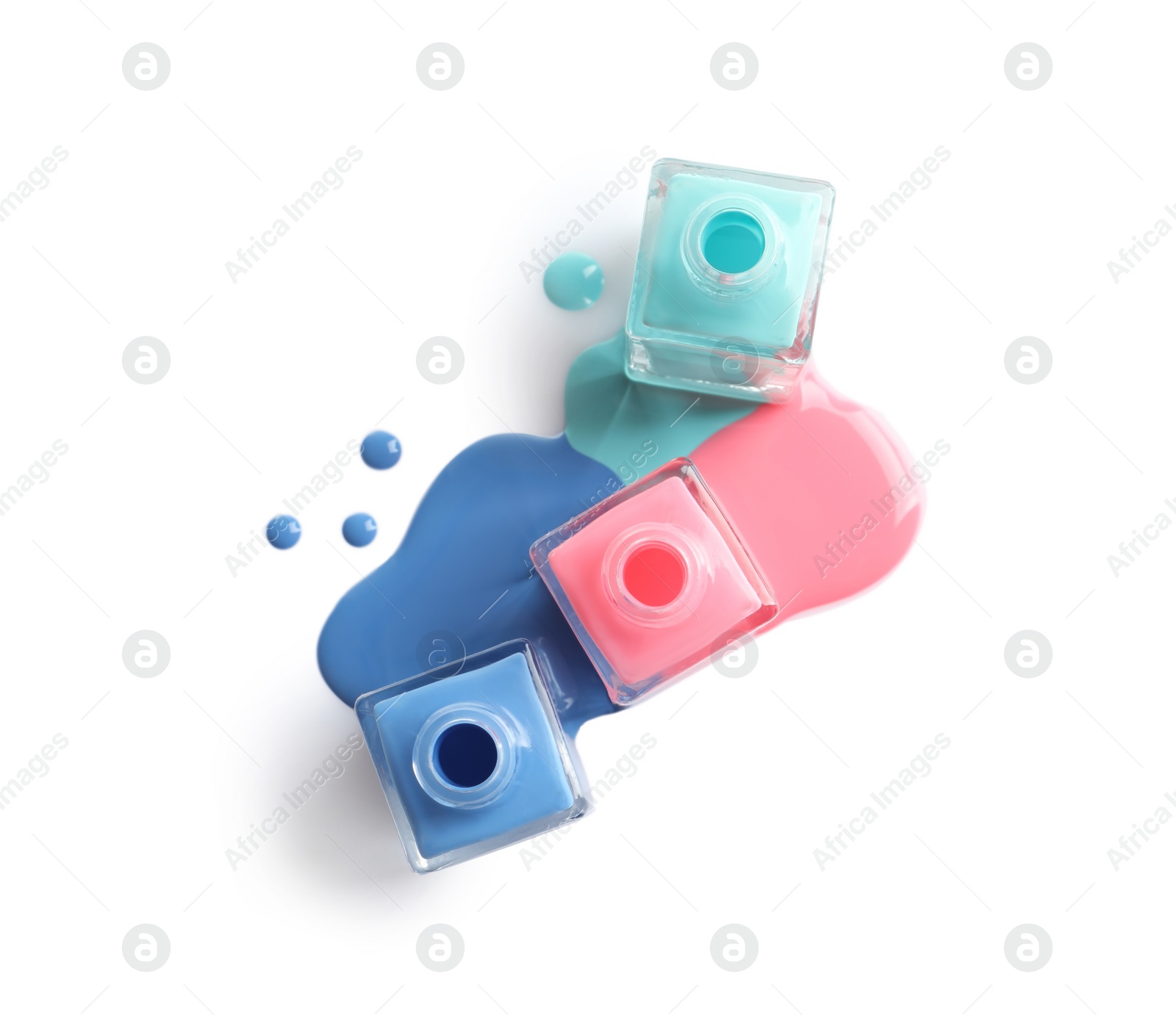 Photo of Spilled different nail polishes with bottles on white background, top view