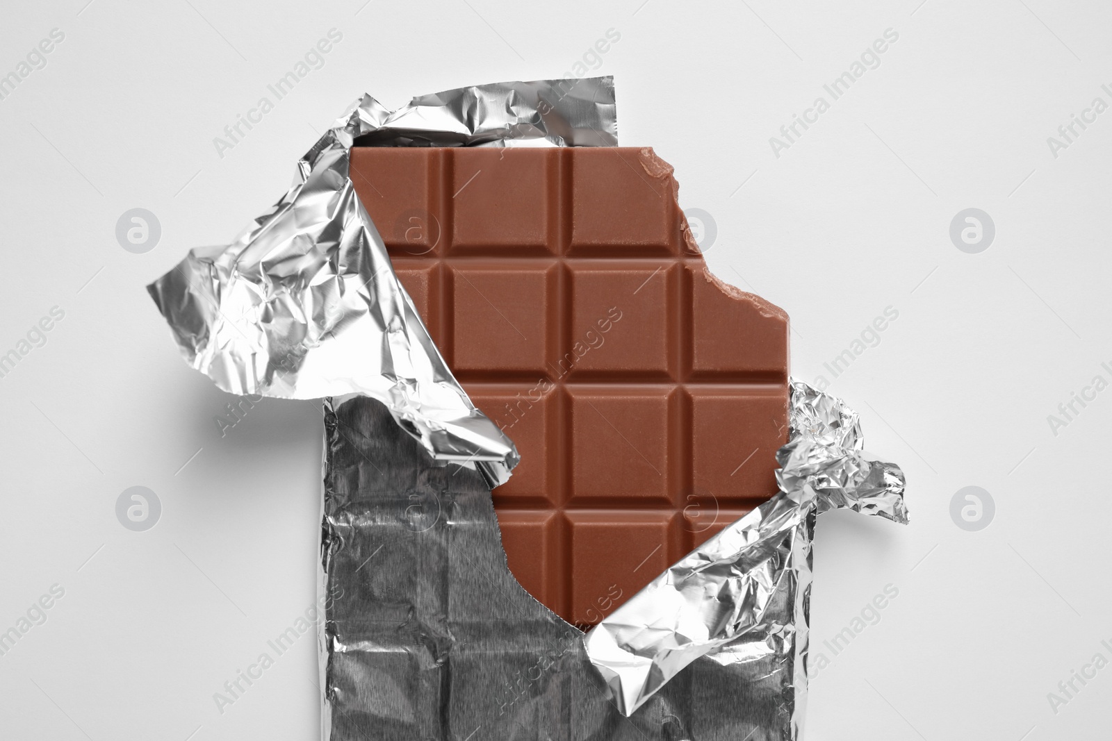 Photo of Delicious chocolate bar on white background, top view