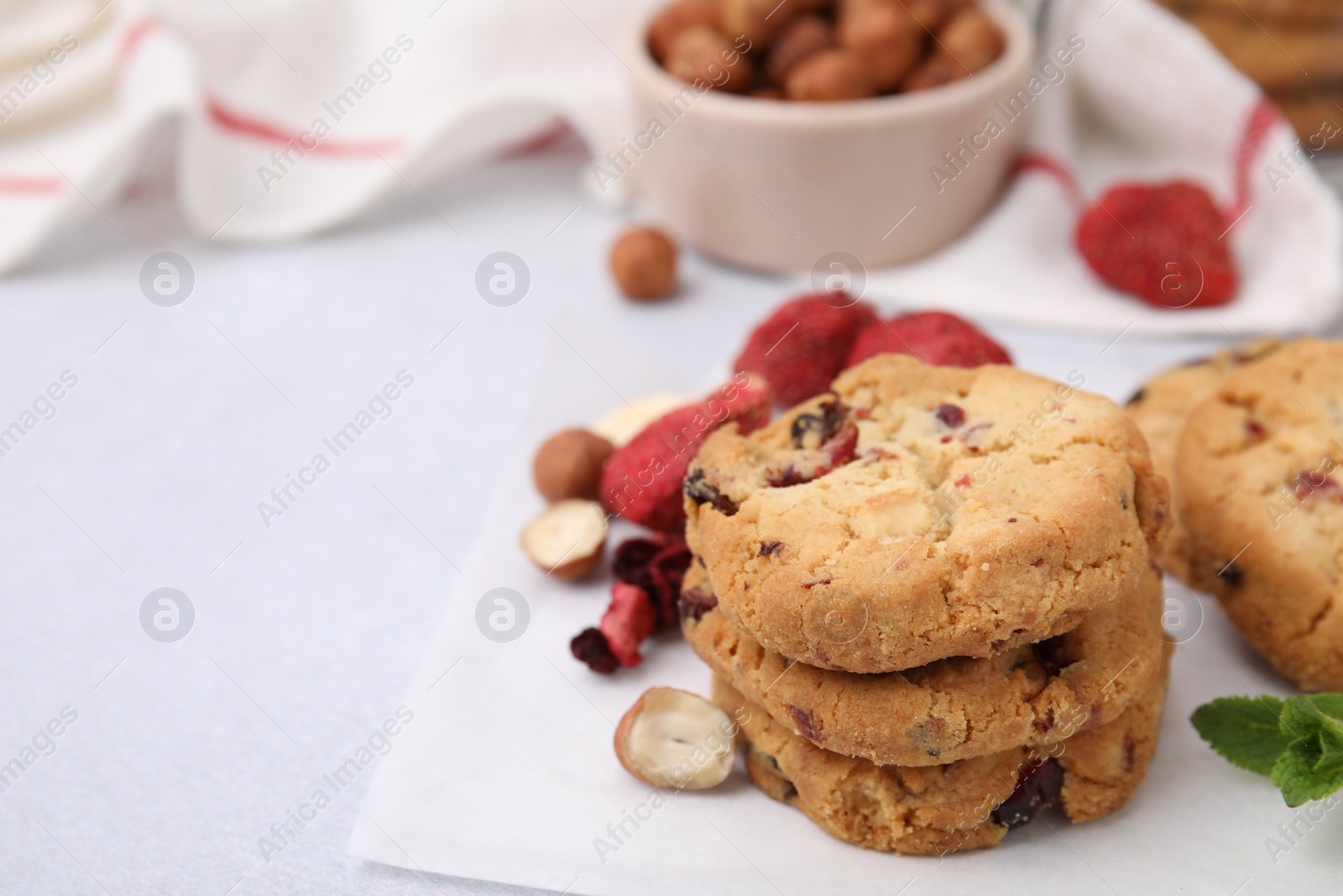 Cookies with freeze dried fruits, nuts and mint on white table, closeup. Space for text Photo of Cookies with freeze dried fruits, nuts and mint on white table, closeup. Space for text