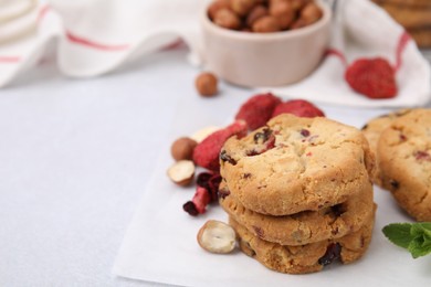 Photo of Cookies with freeze dried fruits, nuts and mint on white table, closeup. Space for text