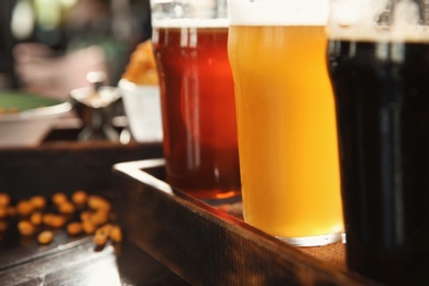 Glasses of tasty beer on wooden table, closeup