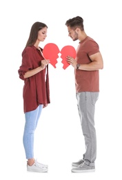 Photo of Young couple with torn paper heart on white background. Relationship problems