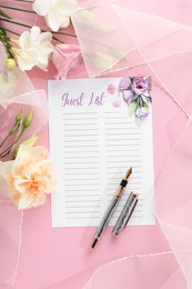 Photo of Guest list, pen, tulle fabric and beautiful flowers on pink background, flat lay. Space for text