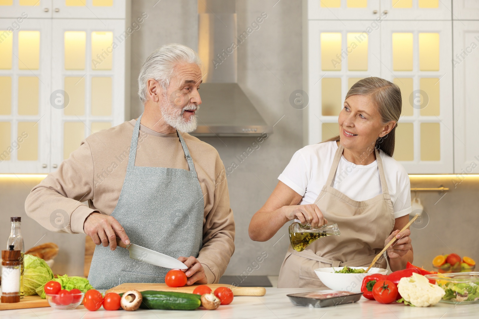 Photo of Happy senior couple cooking together in kitchen