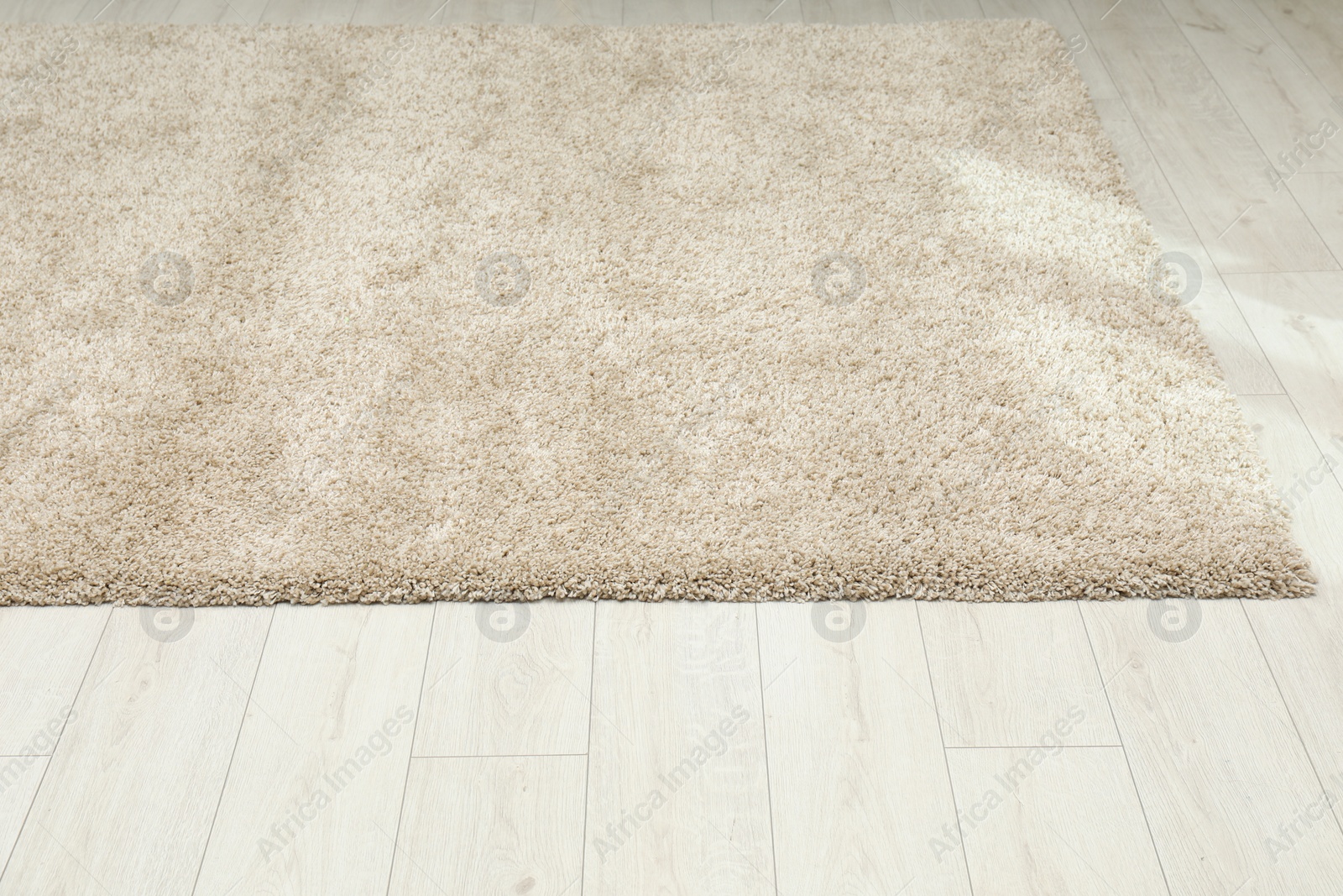 Photo of Soft beige carpet on white laminated floor indoors