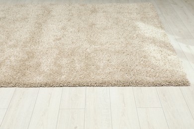 Photo of Soft beige carpet on white laminated floor indoors