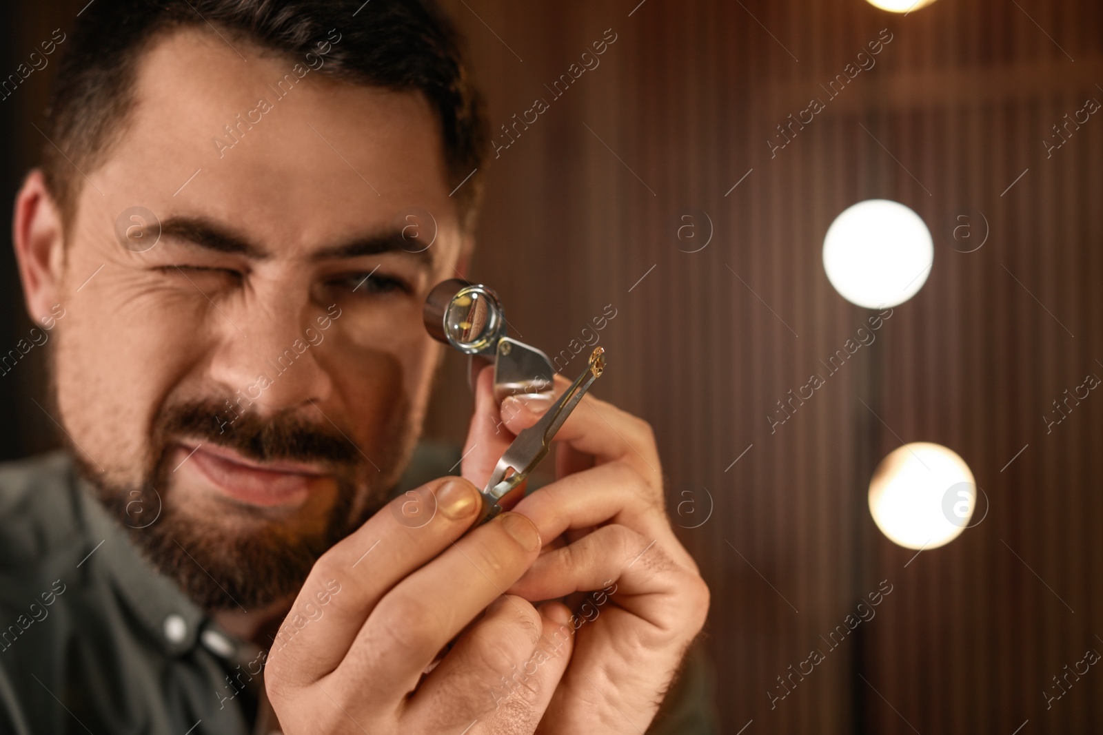 Photo of Jeweler working with gemstone on blurred background