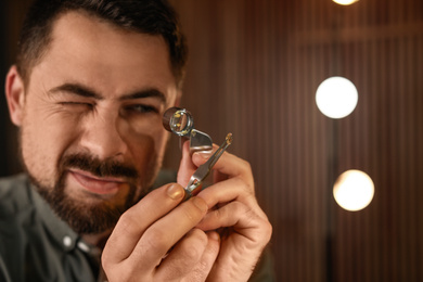 Photo of Jeweler working with gemstone on blurred background