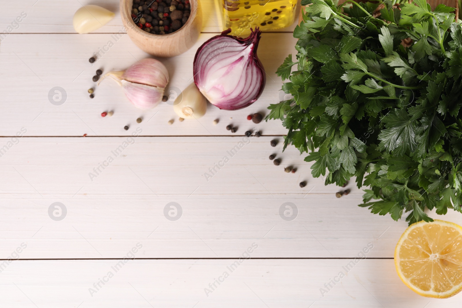 Photo of Fresh green parsley, spices and other products on white wooden table, flat lay. Space for text