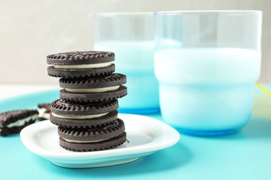 Photo of Tasty chocolate cookies with cream and milk on tray. Space for text