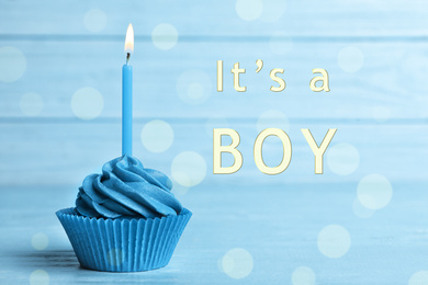 Image of Baby shower cupcake with candle for boy on light blue table