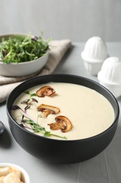 Photo of Delicious cream soup with mushrooms on light table