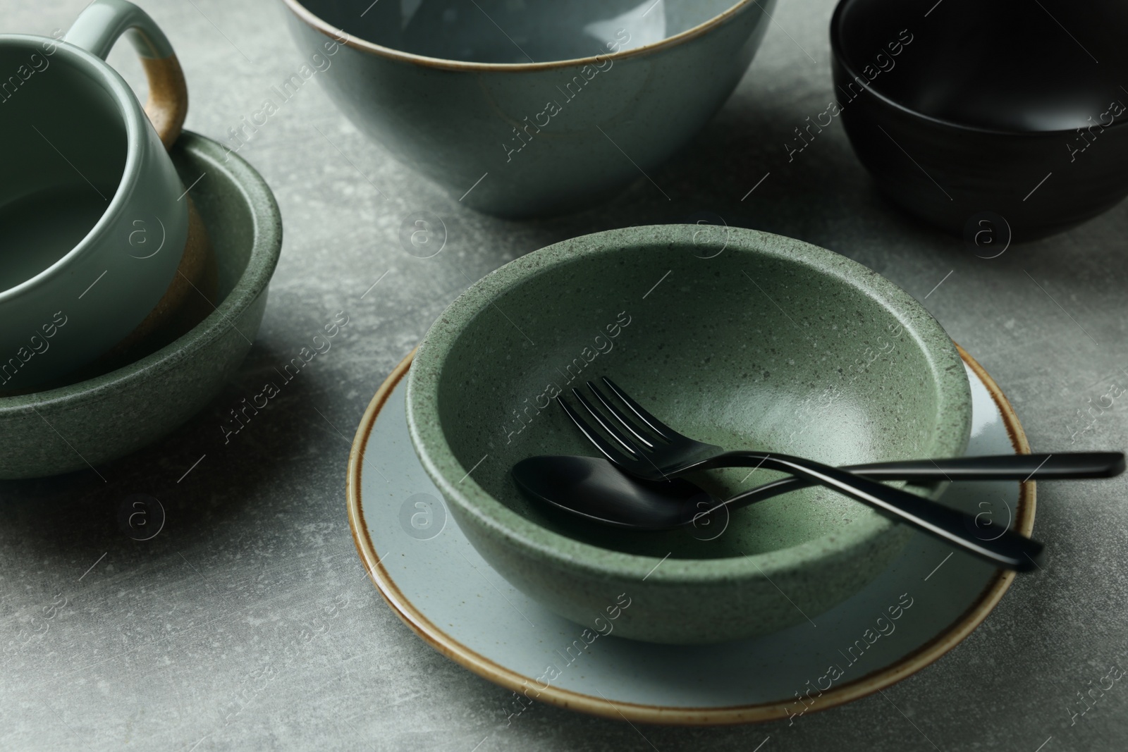 Photo of Stylish empty dishware and cutlery on light grey table, closeup