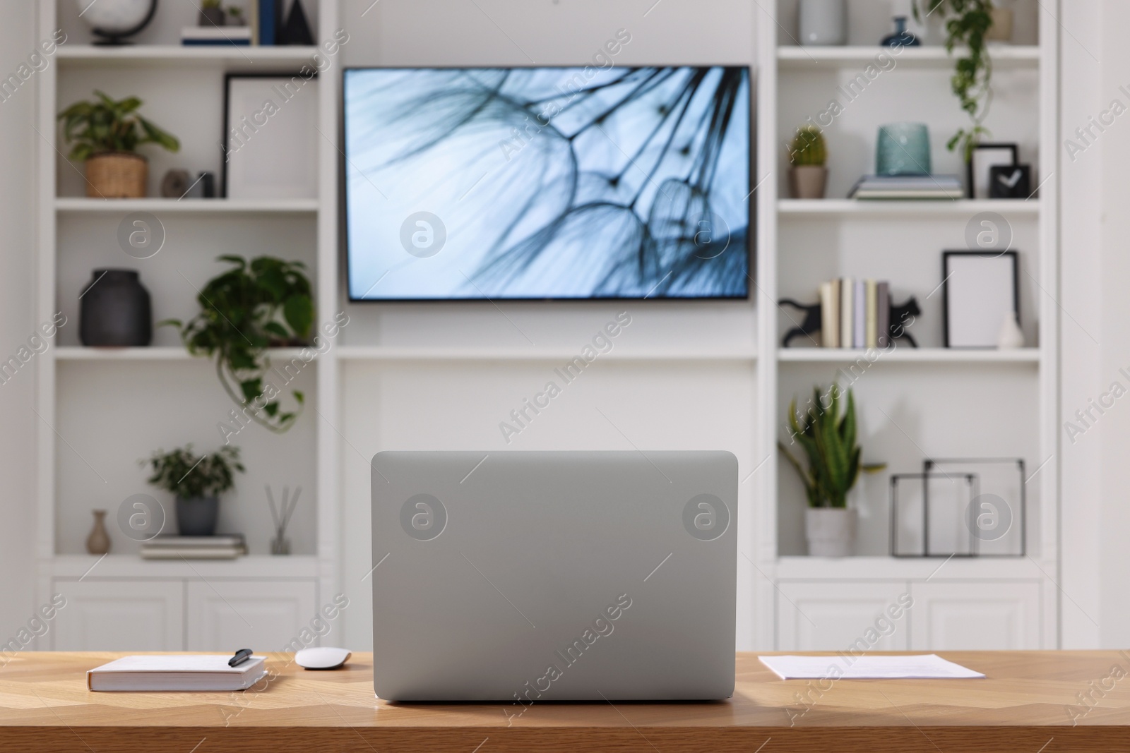 Photo of Cosy workplace with laptop near tv area. Interior design