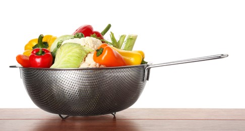 Photo of Metal colander with different vegetables on wooden table against white background