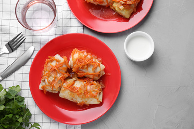 Photo of Delicious cabbage rolls served on grey table, flat lay