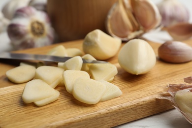 Photo of Fresh chopped garlic on wooden board, closeup. Organic product