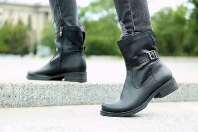 Photo of Woman wearing comfortable stylish boots outdoors, closeup