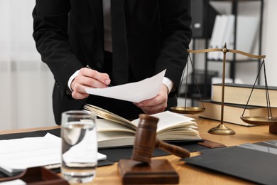 Photo of Lawyer working with document at wooden table, closeup