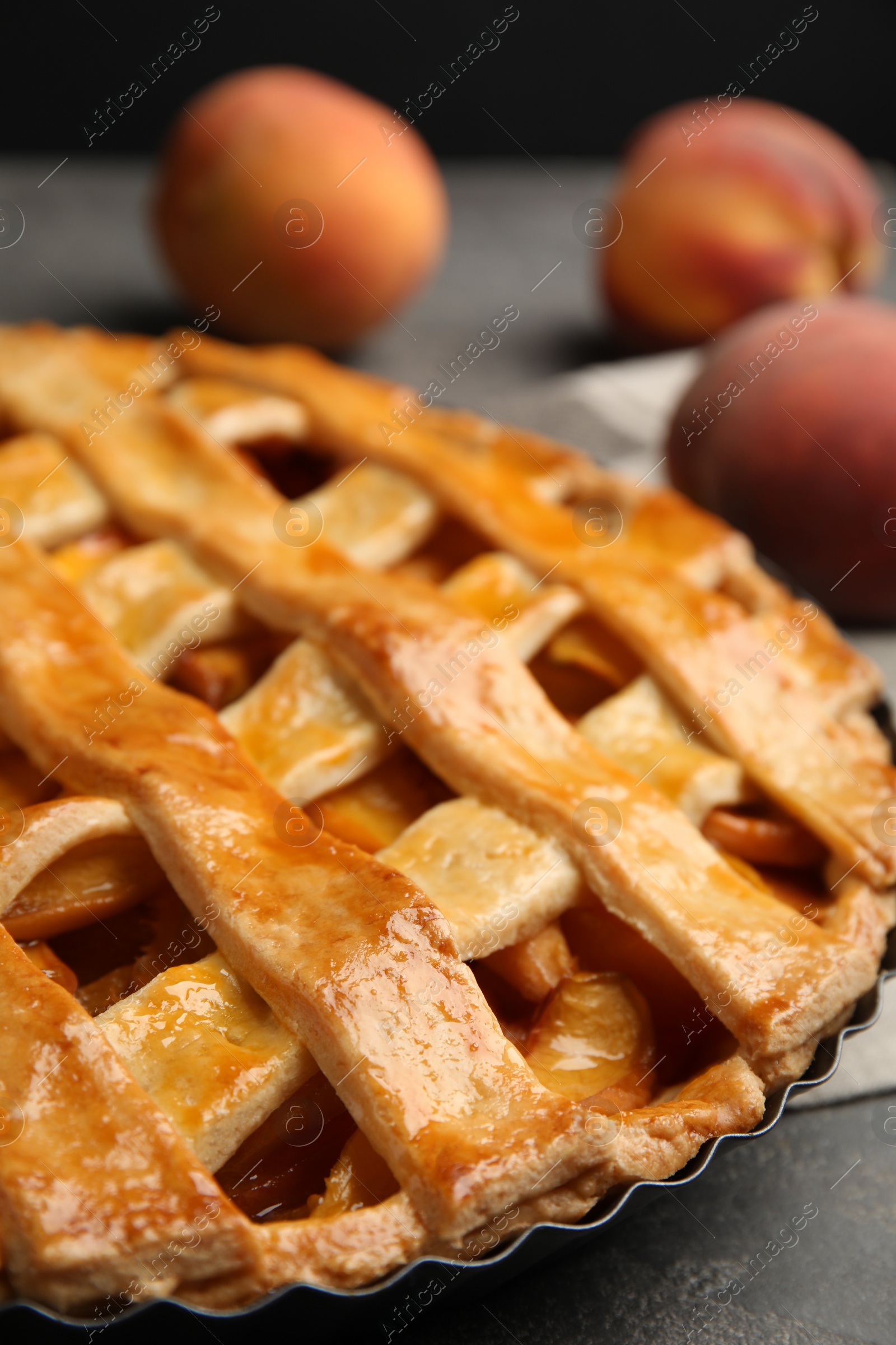 Photo of Delicious fresh peach pie on grey table, closeup