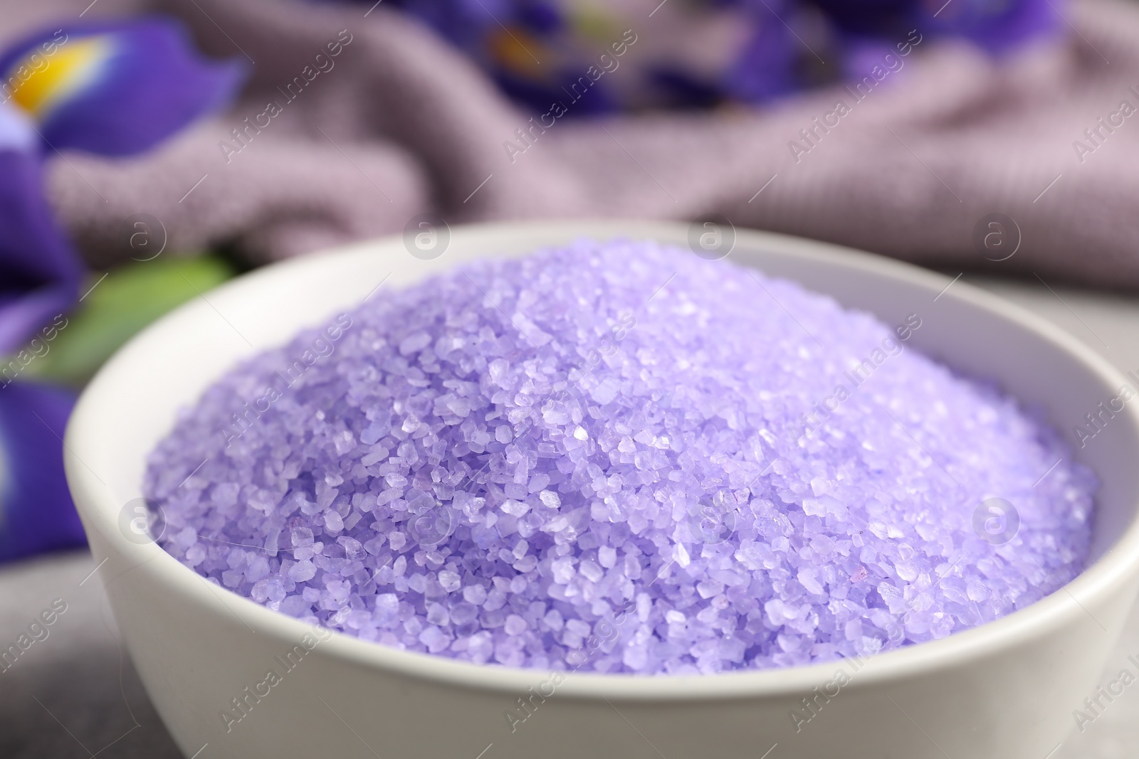 Photo of Natural sea salt in bowl on table, closeup