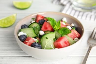 Photo of Delicious salad with watermelon served on white wooden table, closeup