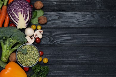 Photo of Different vegetables on black wooden table, flat lay with space for text. Vegan diet