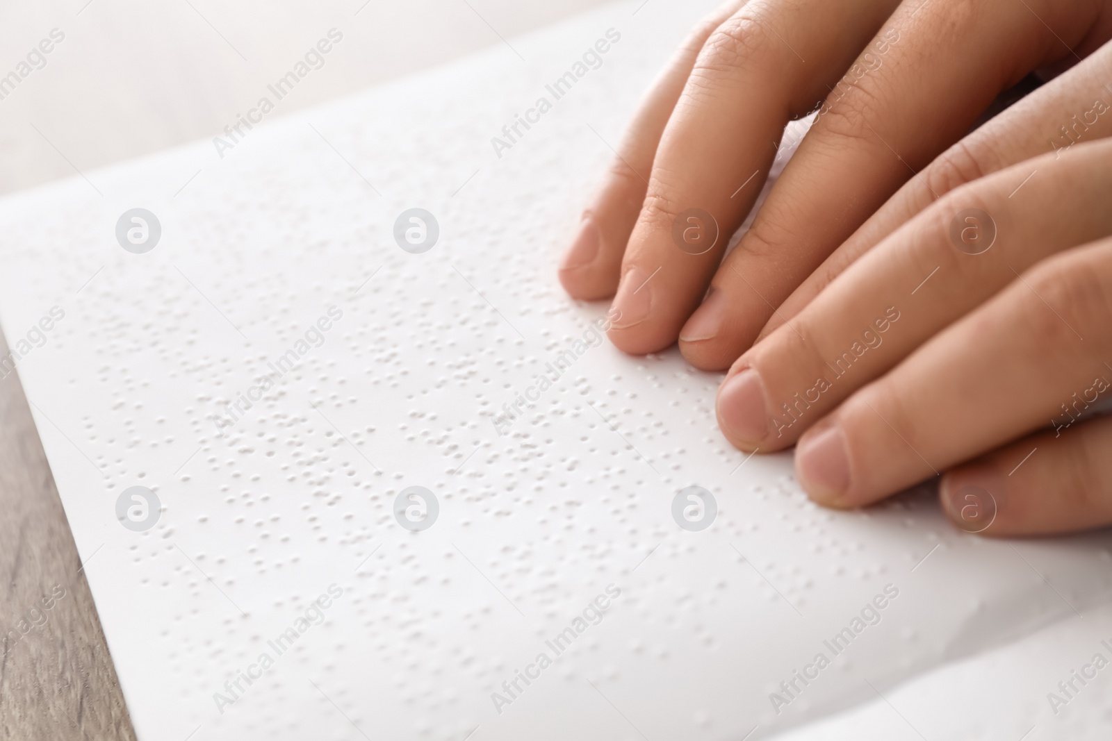 Photo of Blind man reading book written in Braille, closeup