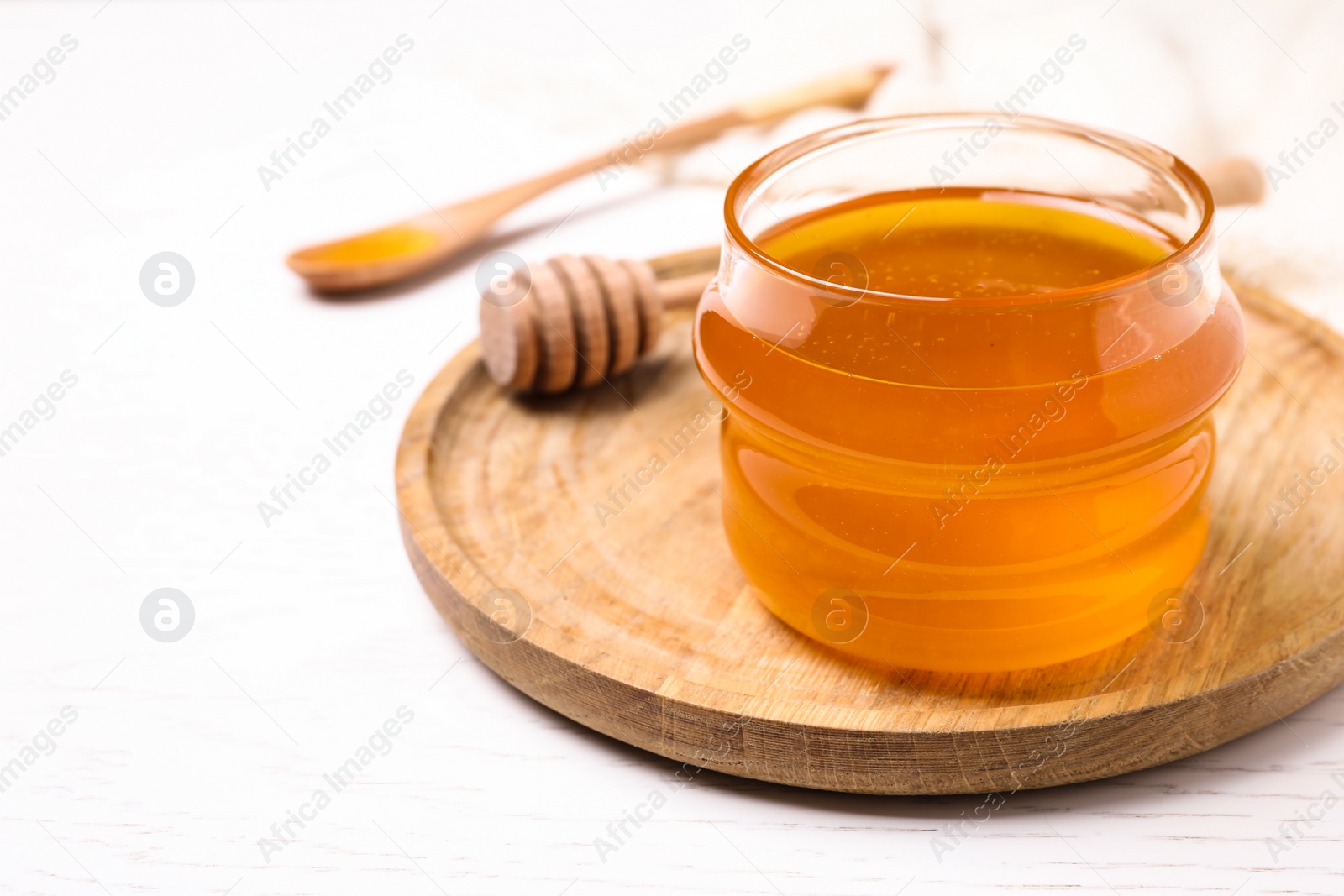 Photo of Tasty aromatic honey on white wooden table