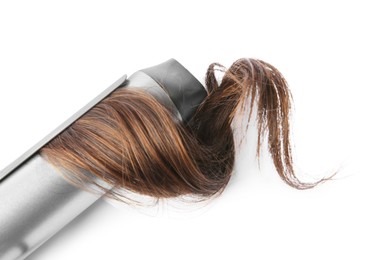 Curling iron with brown hair lock on white background, top view