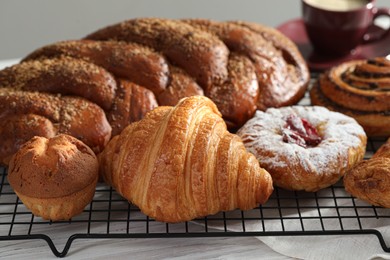 Photo of Different tasty freshly baked pastries on white wooden table, closeup