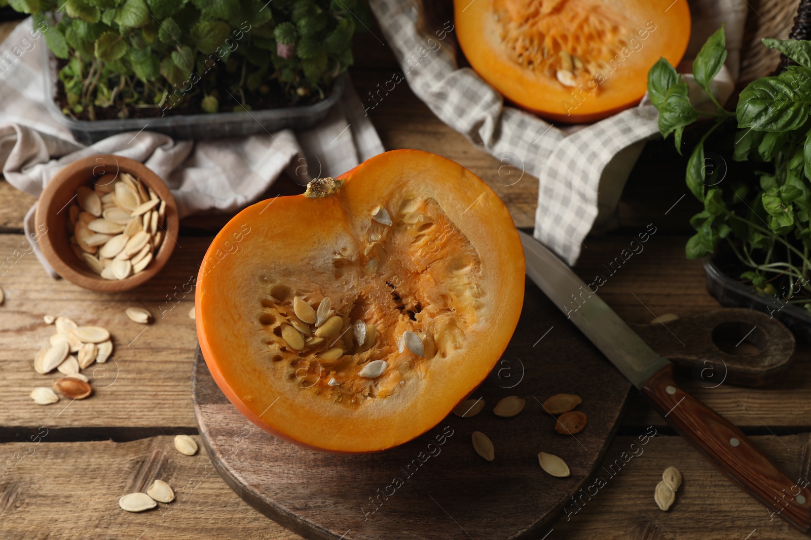 Photo of Cut fresh ripe pumpkin on wooden table, above view