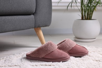 Photo of Pink soft slippers on carpet indoors, closeup