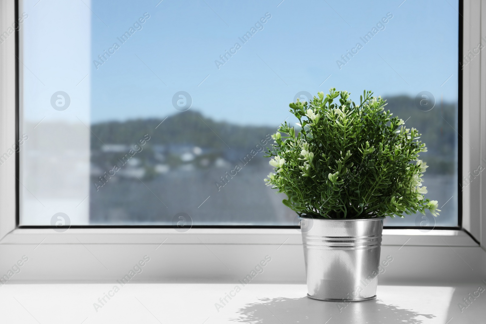 Photo of Artificial potted herb on sunny day on windowsill indoors, space for text. Home decor