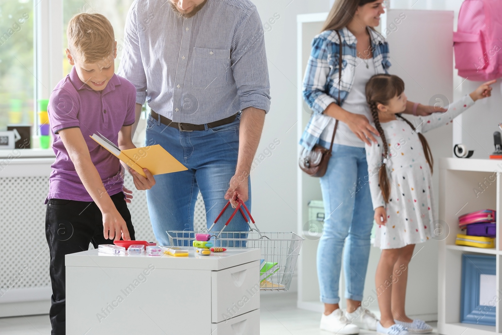 Photo of Cute boy with father choosing school stationery in store