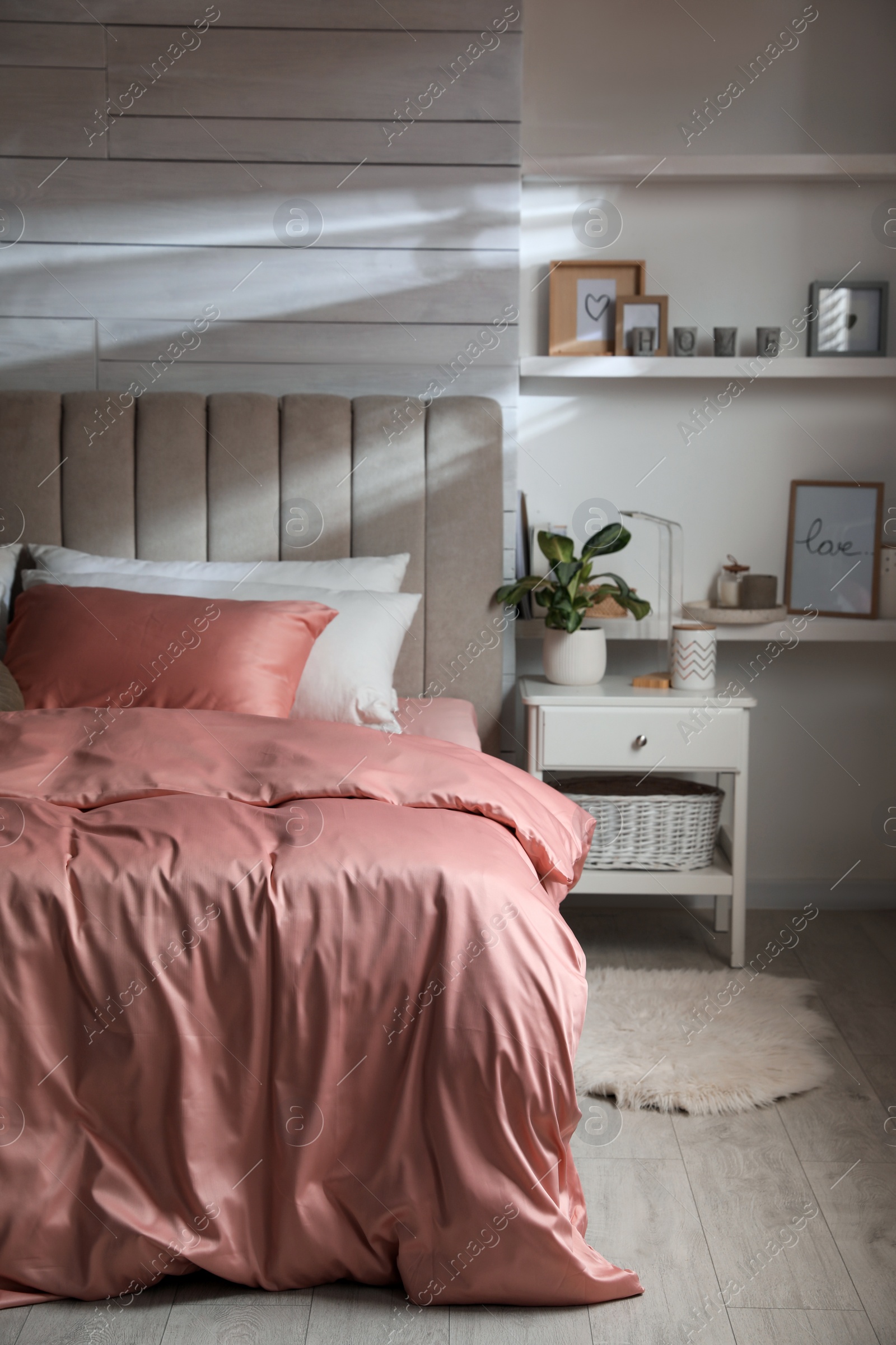 Photo of Bed with beautiful silky linens in stylish room interior