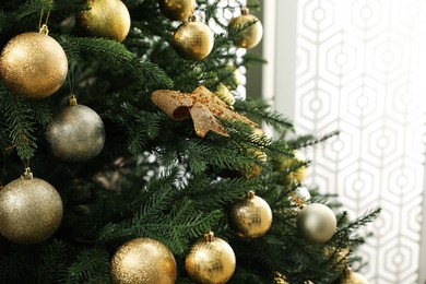 Beautifully decorated Christmas tree in room, closeup. Space for text