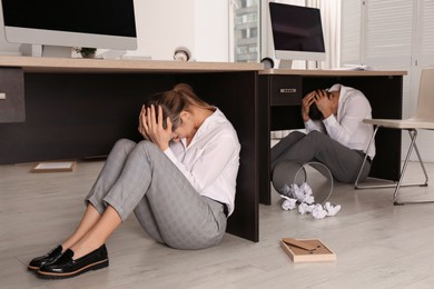 Photo of Scared employees hiding under office desks during earthquake