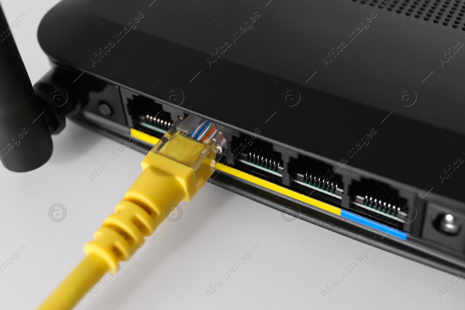 Photo of Connected cable to router on white table, closeup. Wireless internet communication