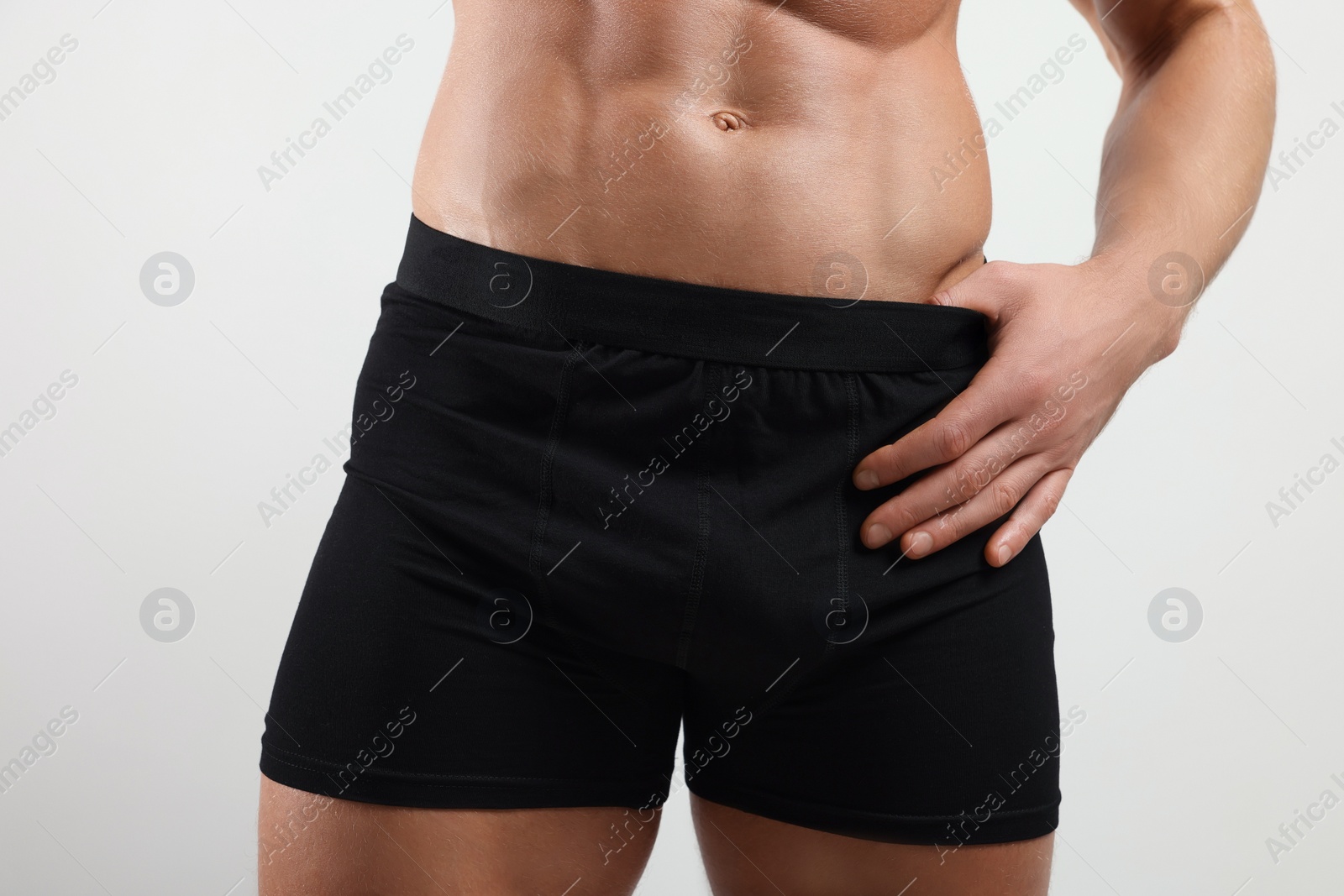 Photo of Young man is stylish black underwear on light grey background, closeup