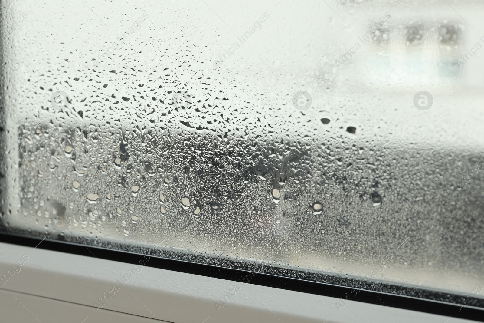 Photo of Window glass with drops of condensate indoors, closeup