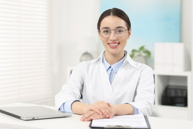 Photo of Medical consultant with glasses at table in clinic