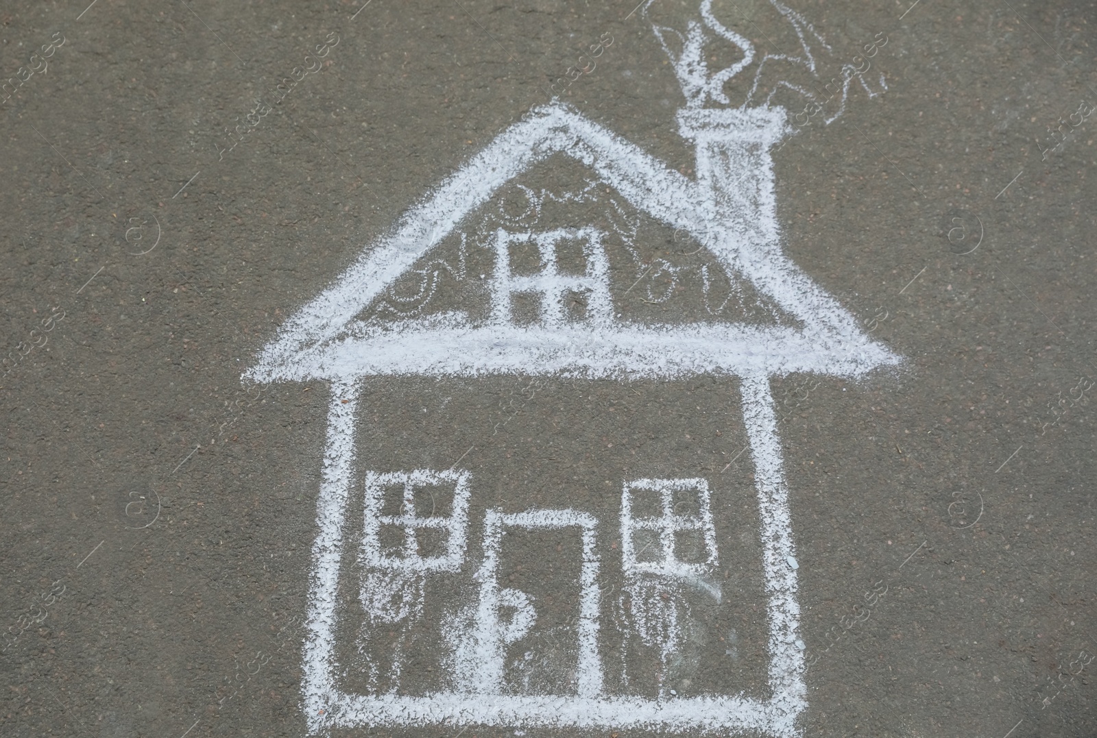 Photo of Child's chalk drawing of house on asphalt, top view